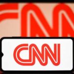 CNN logo on phone and screen background.