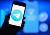 Russia Blames Telegram for 153,000 CRIMES A smartphone displaying the Telegram logo against a blue background