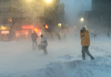 People walking in a snowstorm on a city street