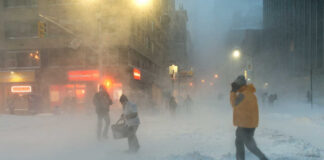 People walking in a snowstorm on a city street