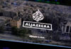 Al Jazeera logo over aerial view of cityscape