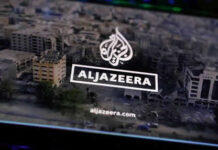 Al Jazeera logo over aerial view of cityscape