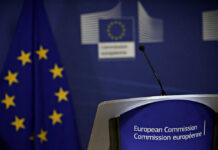 EUROPE CRACKS DOWN: New Deportation Hubs Unveiled European Commission podium and flag background.