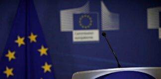 European Commission podium and flag background.