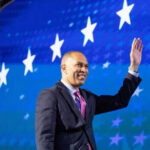 Person waving in front of a starry blue background