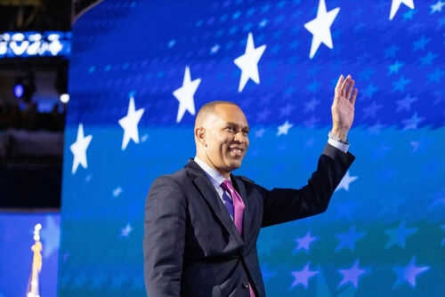 hakeem-jeffries2538652907 Person waving in front of a starry blue background