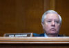 Man sitting at a desk with nameplate Sen Graham