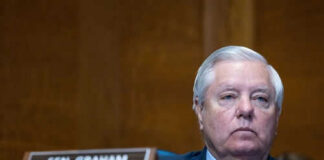 Man sitting at a desk with nameplate Sen Graham
