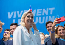 Group taking selfie with smiling woman at event