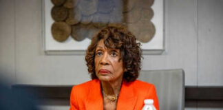 Woman in orange blazer seated at a table