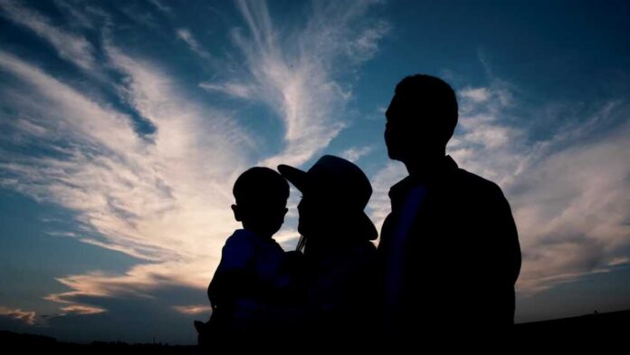 shutterstock_2217304521.jpg Silhouette of a family against a colorful sunset sky