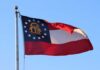 Corrupt Mayor ESCAPES to Georgia—Republicans On ALERT Georgia state flag waving against a clear blue sky