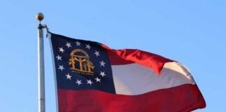 Georgia state flag waving against a clear blue sky