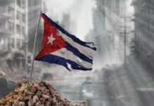 Worn Cuban flag standing on rubble in a desolate urban environment