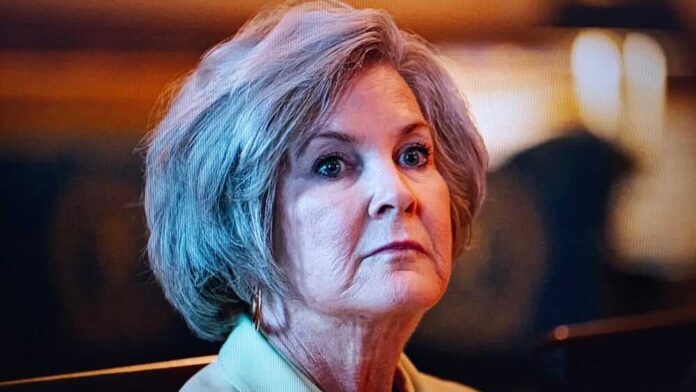 A mature woman with a serious expression in an indoor setting