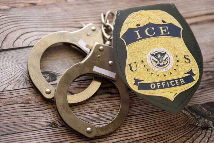 Handcuffs and a police badge on a wooden surface