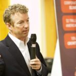 A man speaking into a microphone at a public event