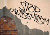 Stop antisemitism graffiti on a worn brick wall