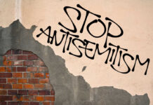 Stop antisemitism graffiti on a worn brick wall
