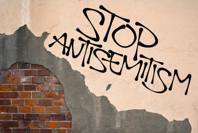 Stop antisemitism graffiti on a worn brick wall