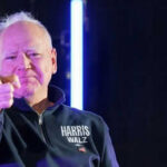 Man pointing with neon lights behind him