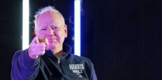 Man pointing with neon lights behind him