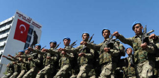 Soldiers marching in formation with blue berets