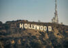 Hollywood sign with communication tower on hillside.