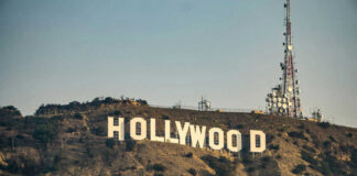 Hollywood sign with communication tower on hillside.