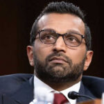 Man wearing glasses in a suit looking thoughtful