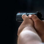 GUNMAN ATTACKS Secret Service—Trump Evacuated Mid-Dinner Person holding a black handgun in firing position