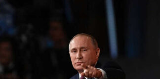 Person pointing while speaking at a podium