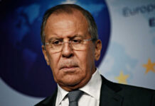 A serious-looking man in formal attire at a press conference