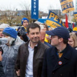 A political candidate surrounded by supporters at a rally