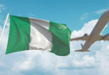 Nigerian flag waving with an airplane flying in the background