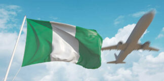 Nigerian flag waving with an airplane flying in the background