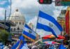 Crowd waving El Salvador flags during a celebration in a city street