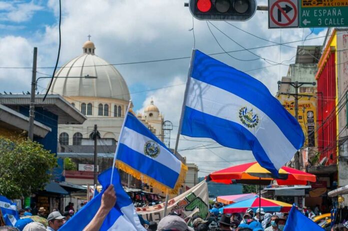 Crowd waving El Salvador flags during a celebration in a city street