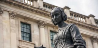 Bronze statue of a woman holding a bird in an urban environment