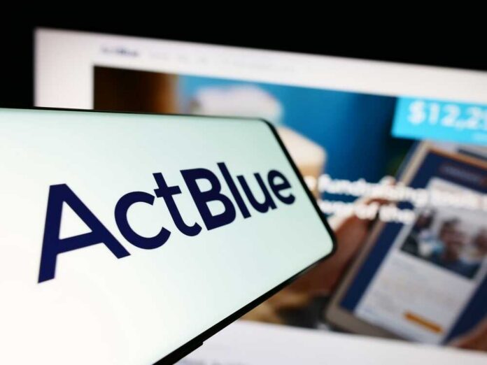 Close-up of a mobile device displaying the ActBlue logo with a blurred background of a fundraising website