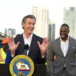 California governor speaking at a construction site with smiling attendees