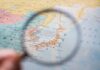A magnifying glass focusing on a map of Japan