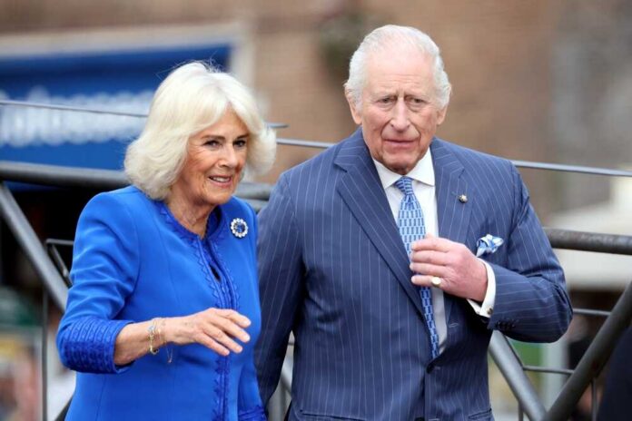 A couple in formal attire walking together, smiling at the camera