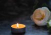 Death at Police Academy: Unapproved Match Turns Deadly A lit candle beside a white flower on a dark surface