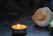 Death at Police Academy: Unapproved Match Turns Deadly A lit candle beside a white flower on a dark surface