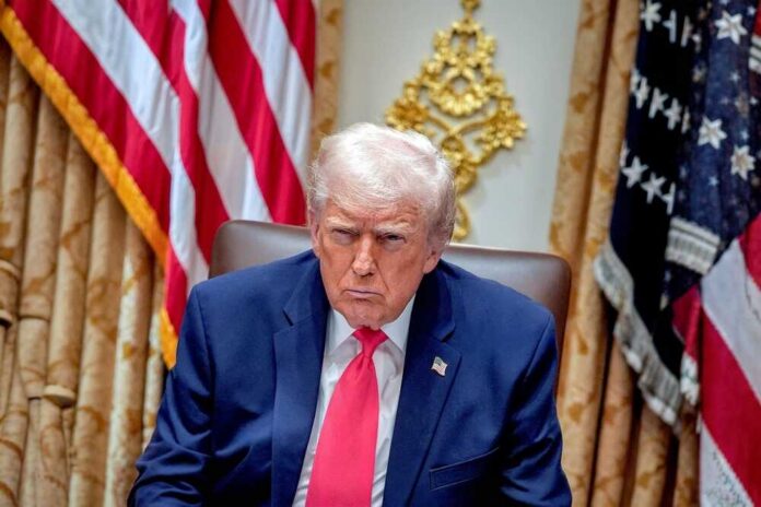 shutterstock_2711671719.jpg Donald Trump seated in the Oval Office with a serious expression