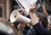 Person holding megaphone at a protest rally.