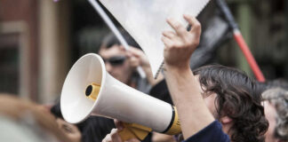 Person holding megaphone at a protest rally.