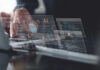 Hands typing on laptop with AI and code overlays