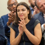 AOC’s Controversial Power Move: 2028 Showdown Woman clapping at an indoor event